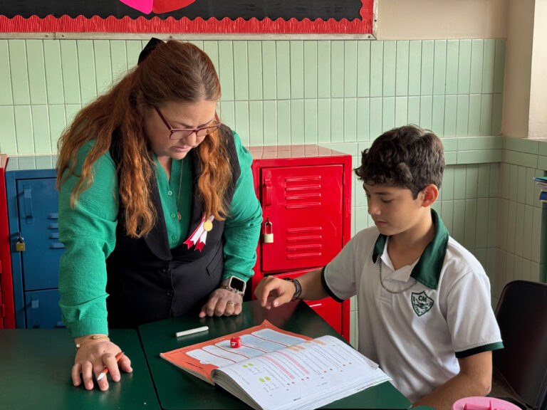 Profesora y estudiante revisando la actividad de la clase dentro del aula