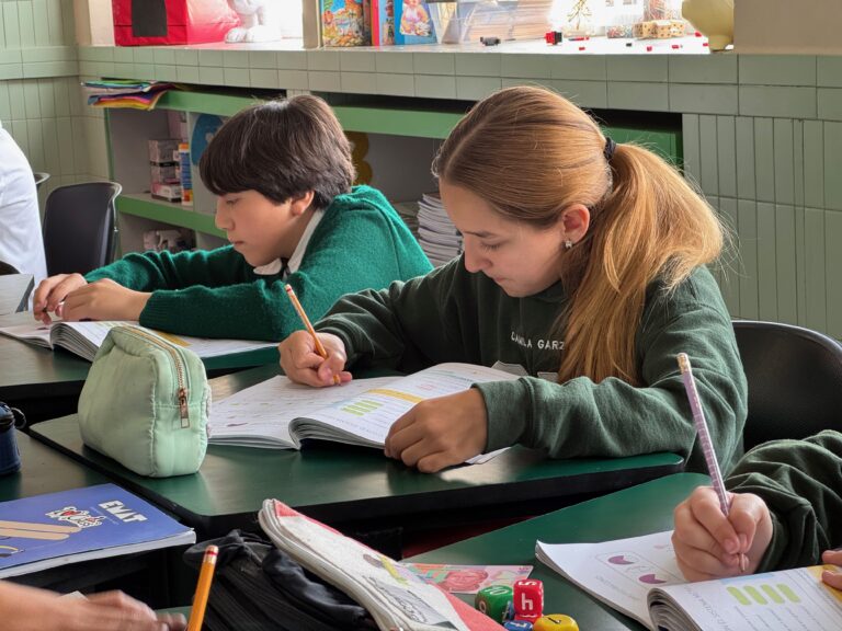 Estudiante de primaria resolviendo un problema en su libreta durante la clase