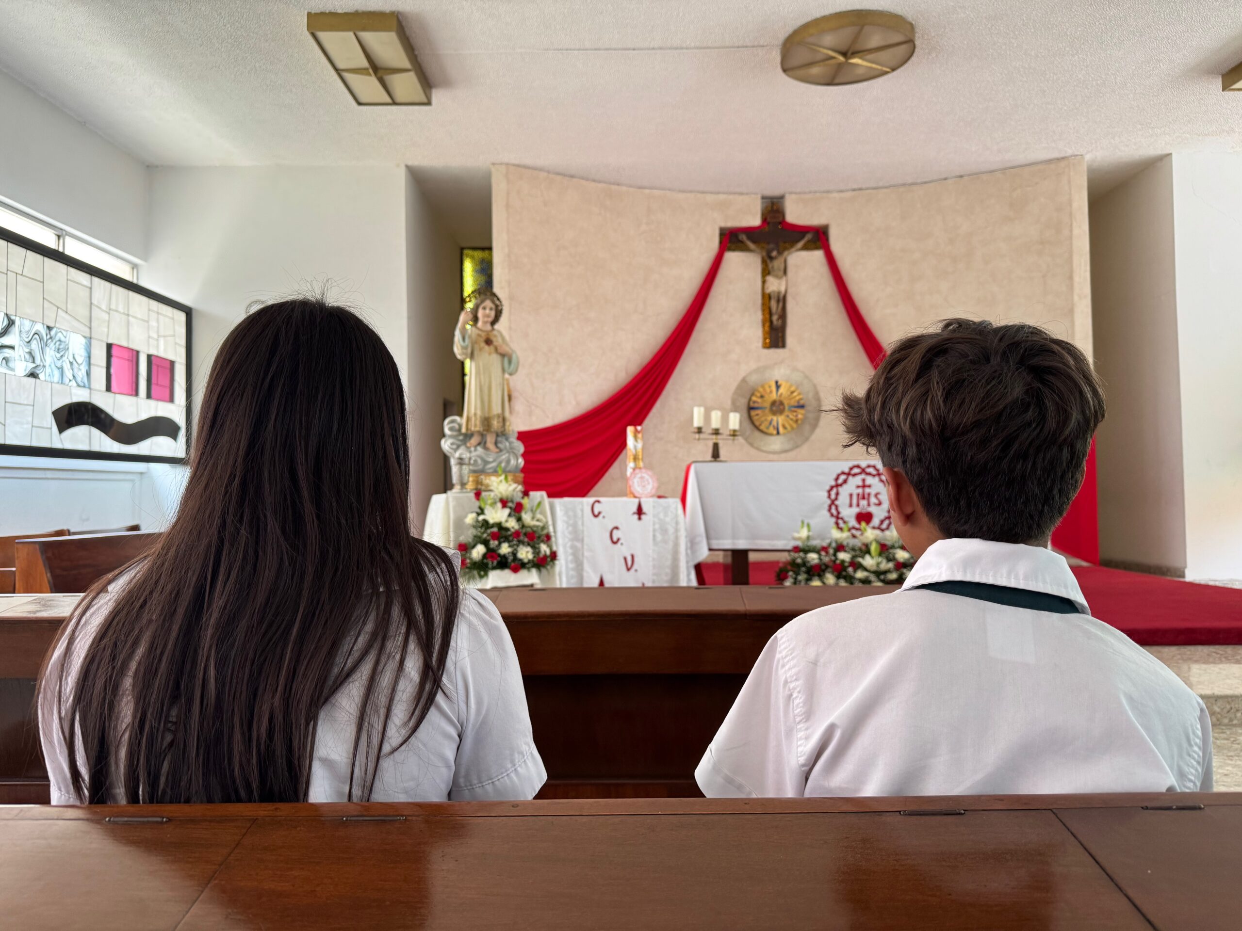 Alumnos de secundaria sentados en las bancas de la capilla del Colegio Mexicano