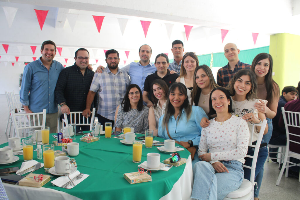 Grupo de exalumnos sonrientes, vestidos profesionalmente, en un evento del Colegio Mexicano