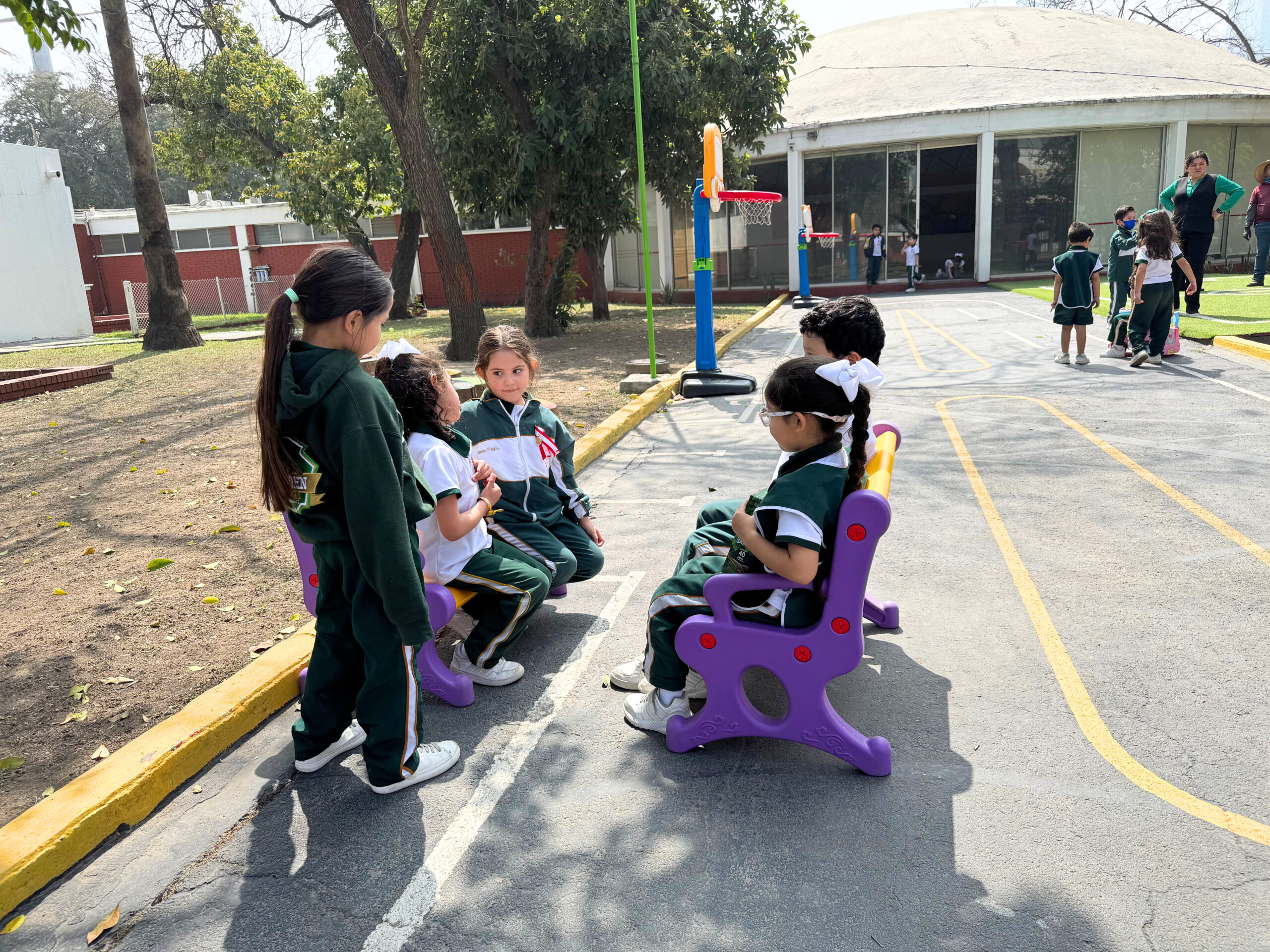 Grupo de niños conviviendo en el patio del colegio mexicano